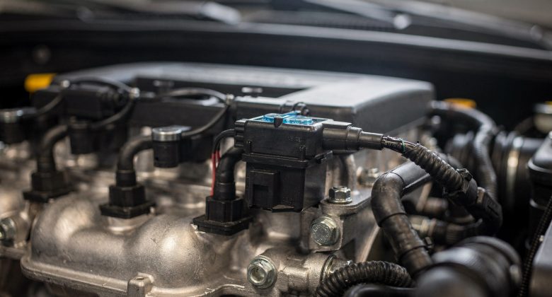 Das Bild zeigt die Zündspule im Motorraum und hilft den Lesern, diese Komponente zu identifizieren.