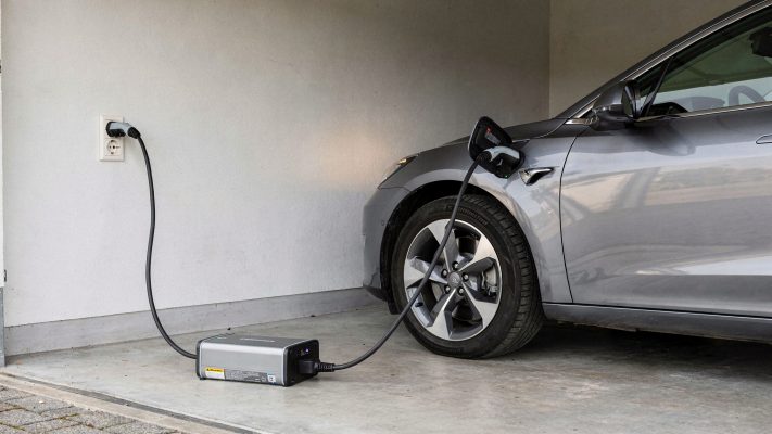 Zeigt das zentrale Szenario des Artikels: langsames Laden zu Hause über die normale Steckdose mit Mode-2-Ladekabel.