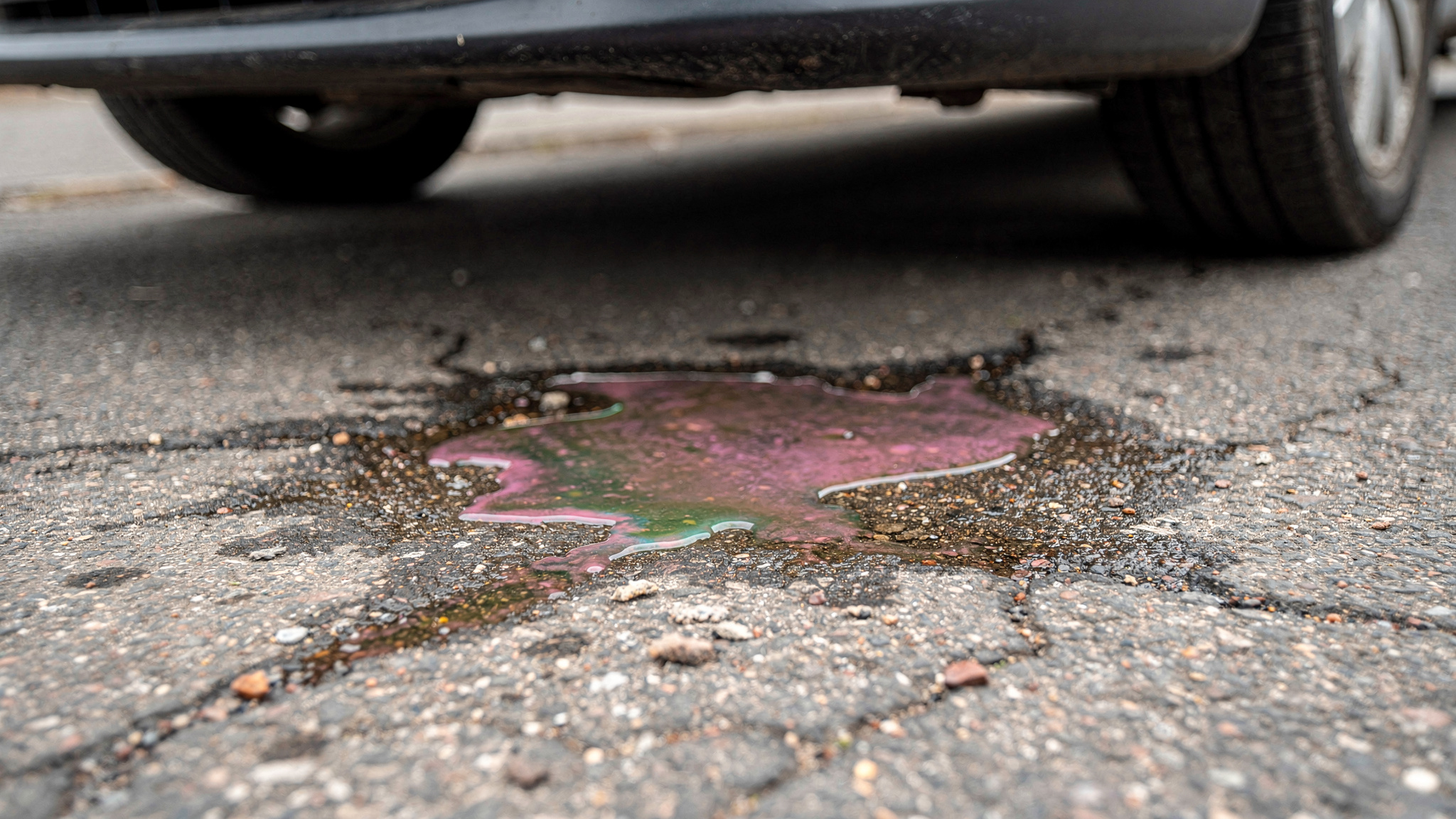 Visualisiert ein typisches, leicht erkennbares Warnzeichen: Pfützen/Tropfen unter dem Fahrzeug.