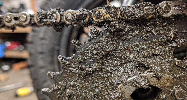 Visualisiert, warum Reinigung wichtig ist: Schmutz/alte Schmierstoffreste als 'Schleifpaste' und Ursache für Verschleiß.