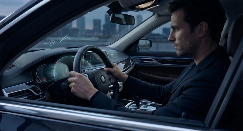 Das Motiv übersetzt die Kernaussage des Artikels unmittelbar ins Bild: Ein Fahrer wird nicht offen, sondern über dezente digitale Hinweise im Cockpit beeinflusst. Die ruhige, realistische Inszenierung wirkt hochwertig und glaubwürdig, während die subtile UI-Ebene den technologischen Aspekt moderner Assistenz- und Komfortfunktionen visuell verständlich macht.