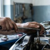 Diese Detailaufnahme transportiert die handwerkliche Kompetenz und die tactile Verbindung zum Fahrzeug – ein Sinnbild für den Mut und das Können hinter der eigenen Reparatur.