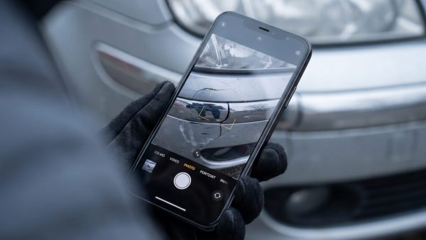 Das Bild stellt das präzise Festhalten von Beweisen in den Mittelpunkt und vermittelt die emotionale Bedeutung von Sorgfalt und Klarheit in der Unfallnachbereitung.