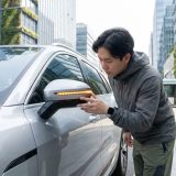 Diese Szene zeigt den alltäglichen Moment der Selbstkontrolle, vermittelt Verantwortung und die Bedeutung des Blinker-Signals im Straßenverkehr.