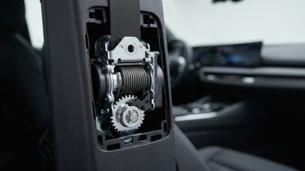 Diese Nahaufnahme macht die komplexe, moderne Technik des Gurtaufrollers sichtbar und vermittelt Vertrauen in die Sicherheitstechnik und Präzision, die hinter scheinbar einfachen Komponenten steckt.
